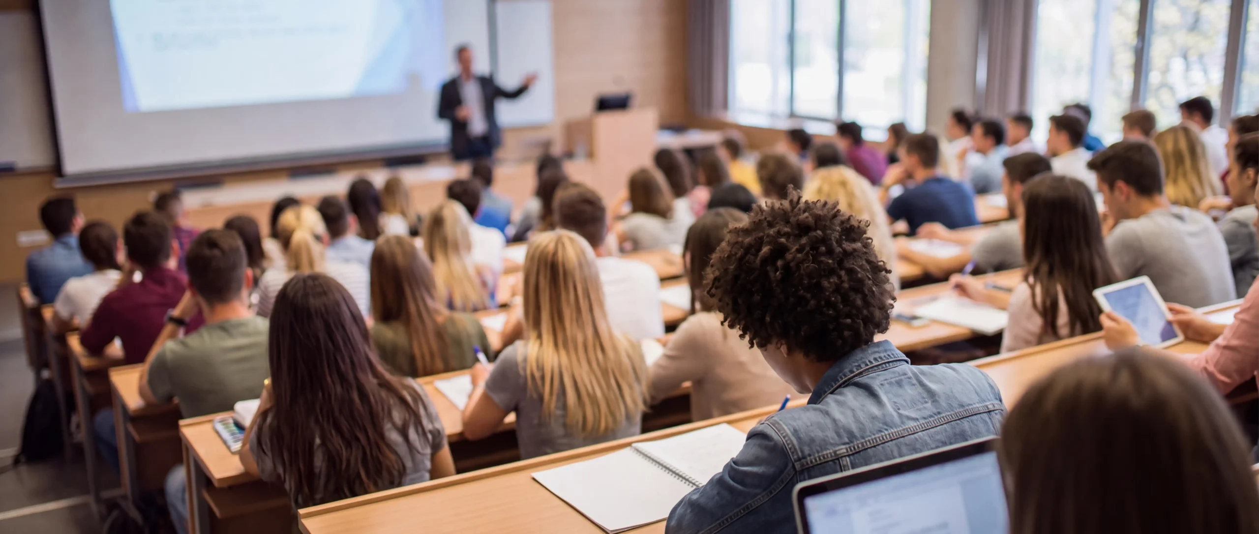Étudiants attentifs dans un amphithéâtre universitaire lors d'un cours