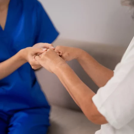 Zoom main patient soignant dans les EHPAD